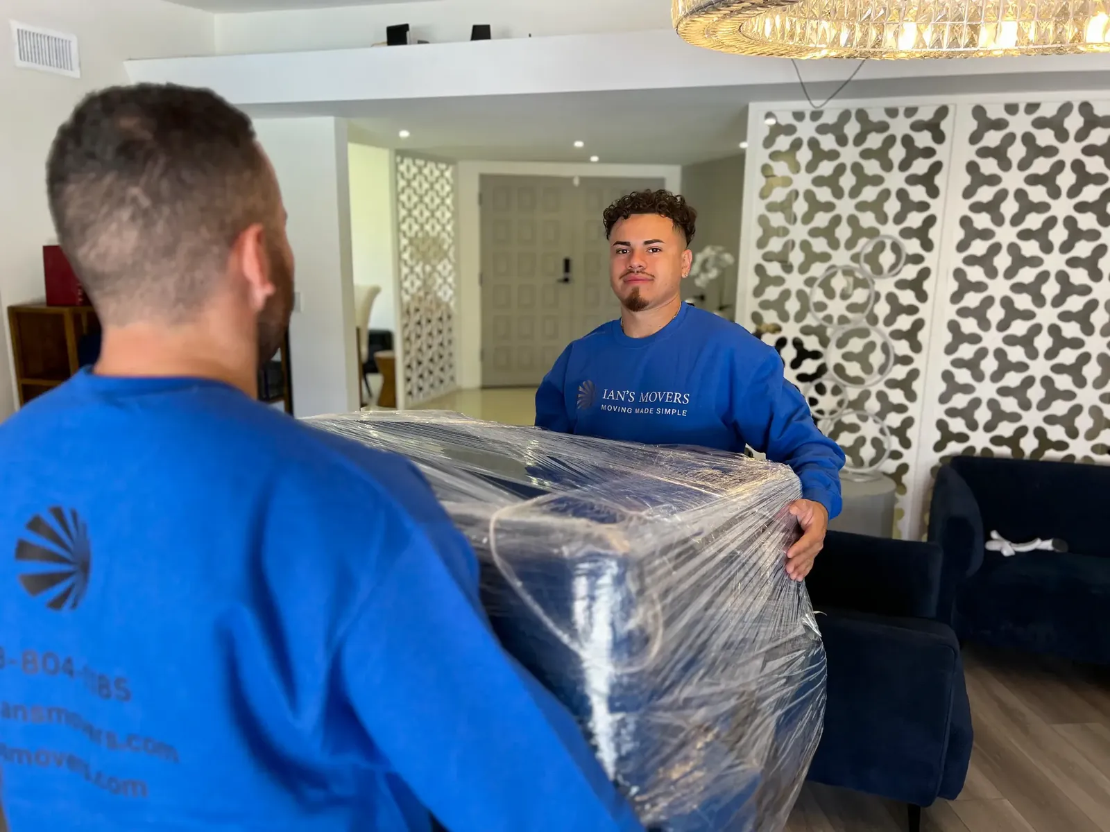 Ian's Movers crew moving wrapped furniture