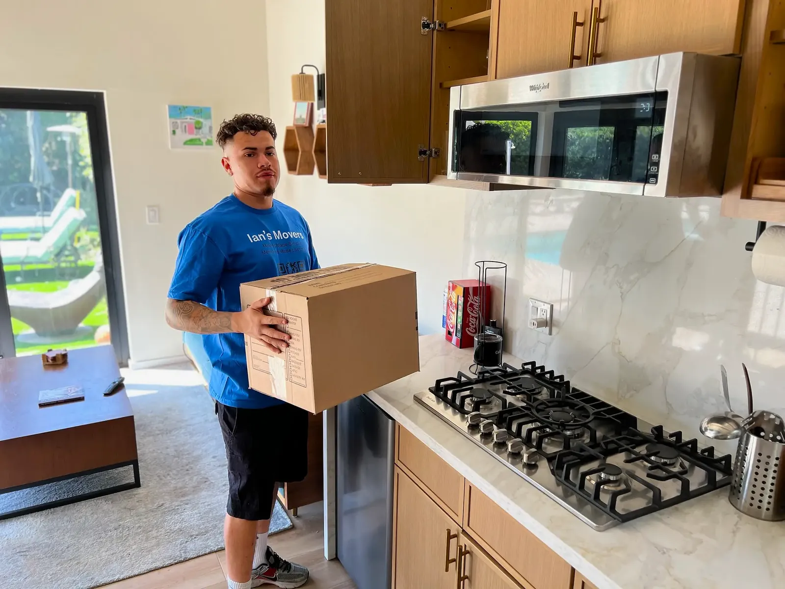 Ian's Movers residential mover carrying a packed box